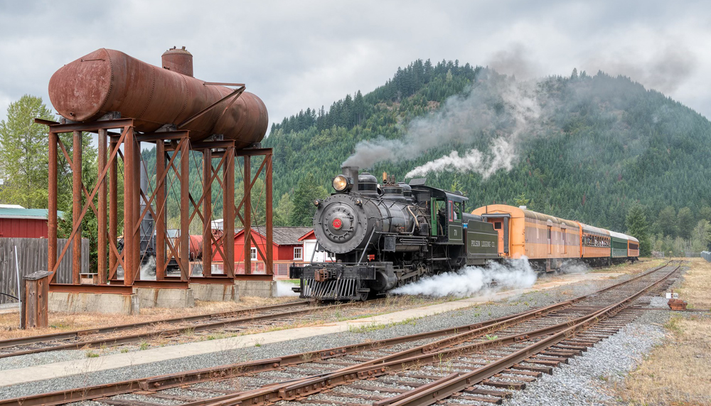 Steam engine pulls up to water tank