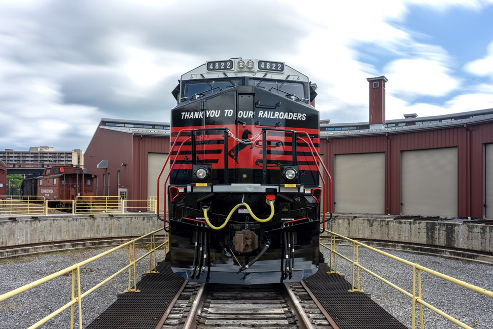 Front of red, white, and black locomotive with slogan "Thank you to our railroaders."