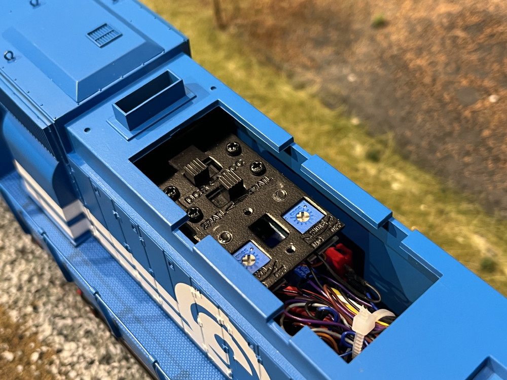 Blue and white model train with access hatch opened