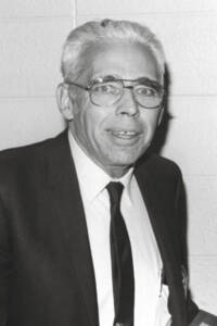 Black-and-white portrait of a smiling man in a suit