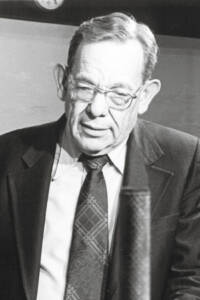 Black-and-white portrait of a man looking down at a layout