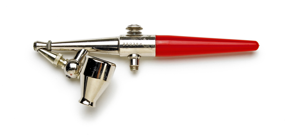 Color photo of airbrush with red handle and plated parts.
