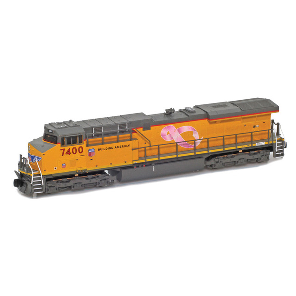 A gray and yellow model locomotive against a white background