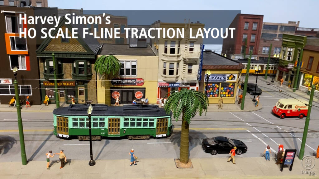 Title screen of layout visit video featuring trolley car, vehicles, and downtown buildings.