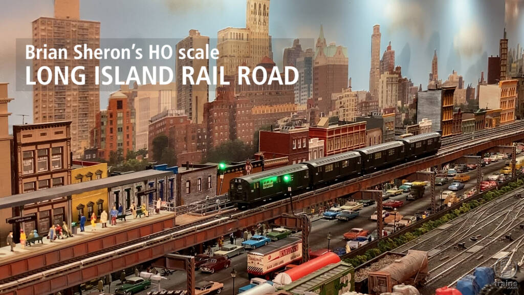 Title screen showing skyline, yard, and elevated line on an HO scale model railroad.
