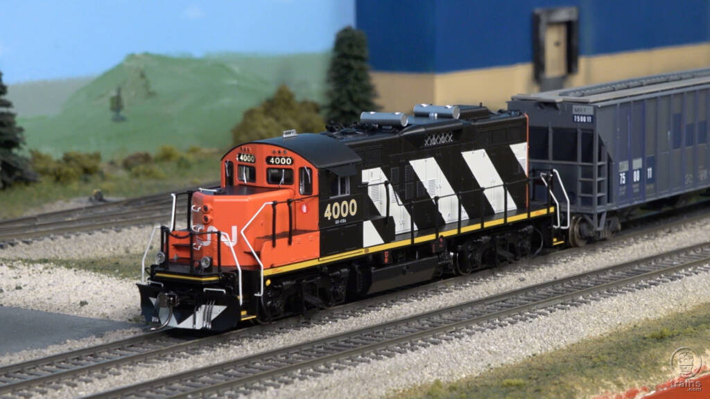 Screen shot from video showing HO scale diesel locomotive painted red, white, and black.