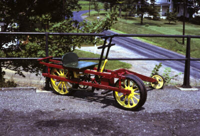 A red with yellow wheels railroad velocipede.