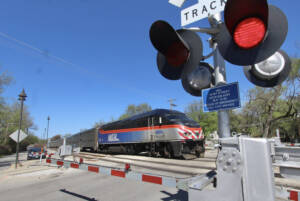 Commuter train passes crossing gate