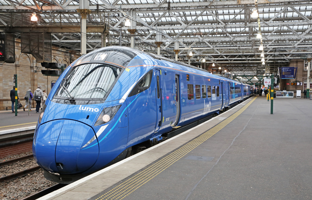 Blue streamlined train at station.