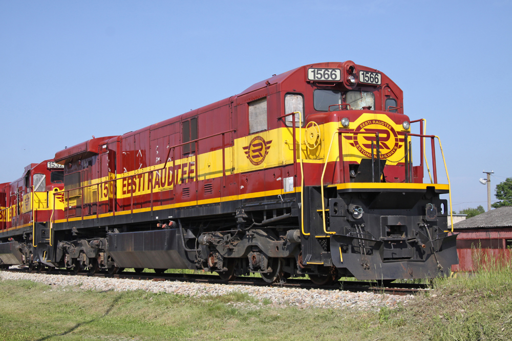 Maroon and yellow locomotive with windows covered for storage