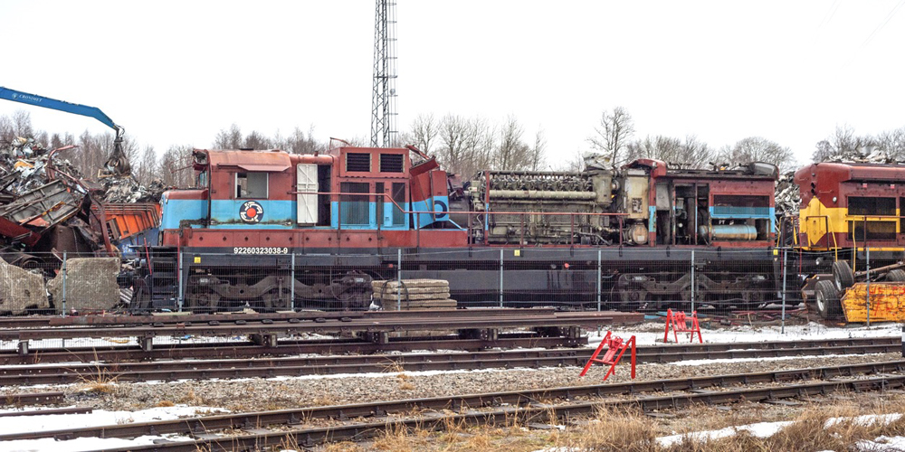 Locomotive in scrapyard with much of long hood removed