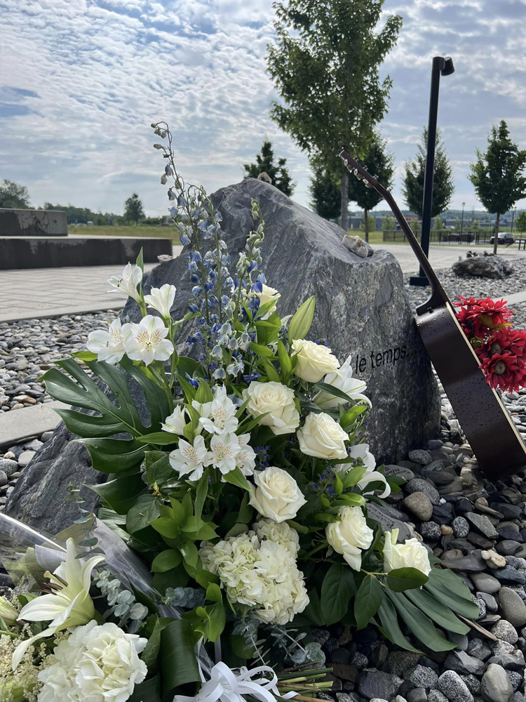 Flowers, guitar at stone memorial