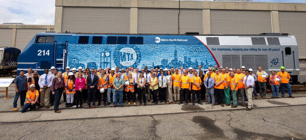 Large group of people posing with locomotive