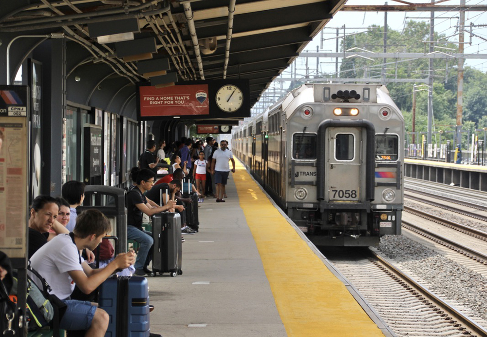 Large number of passengers wait on platform for arriving train