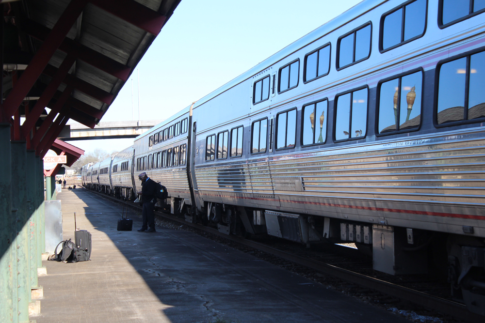 Train with two single-level cars at station; Sightseer cars, with two rows of windows, in foreground