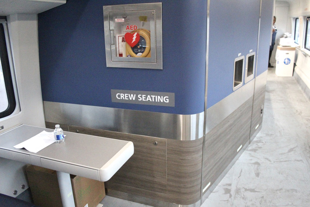 Small table next to wall in cafe car with "Crew Seating" sign