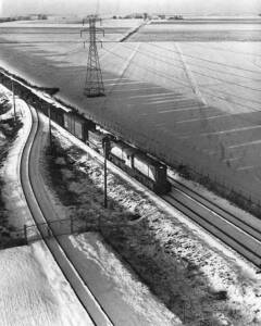 Aerial photo of two diesel locomotives on freight train in snow-covered landscape