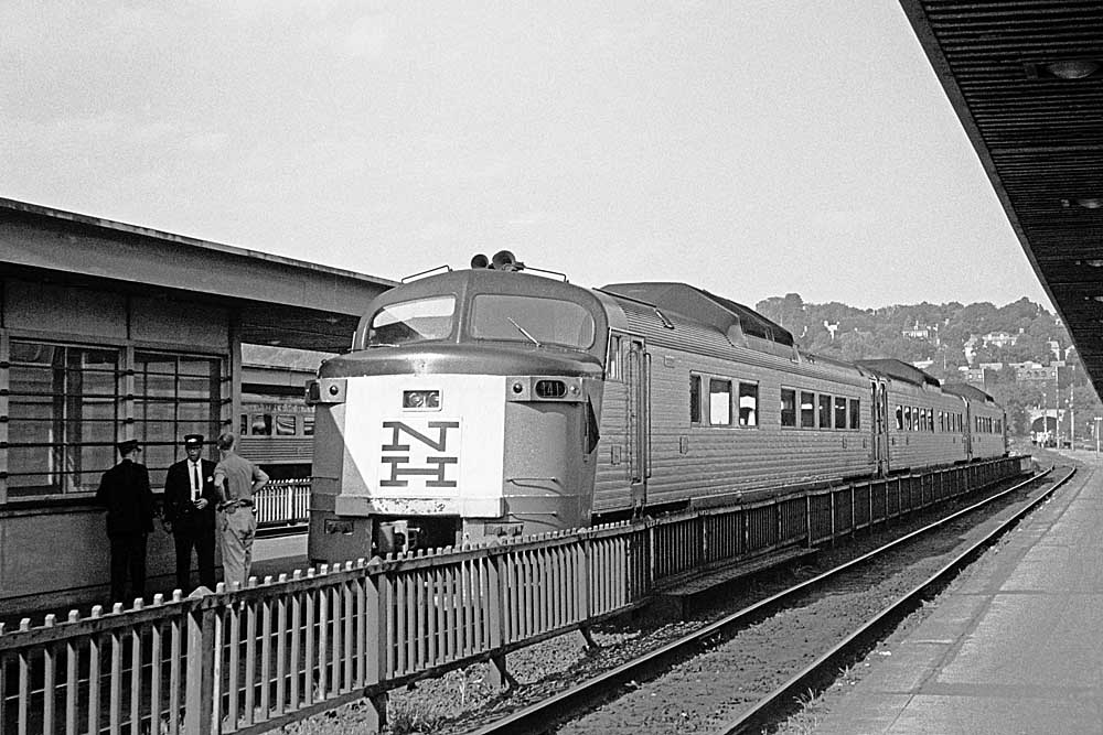 Semi-streamlined stainless steel passenger train at station