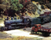 Photo of HO scale steam engine leading train over grade crossing.
