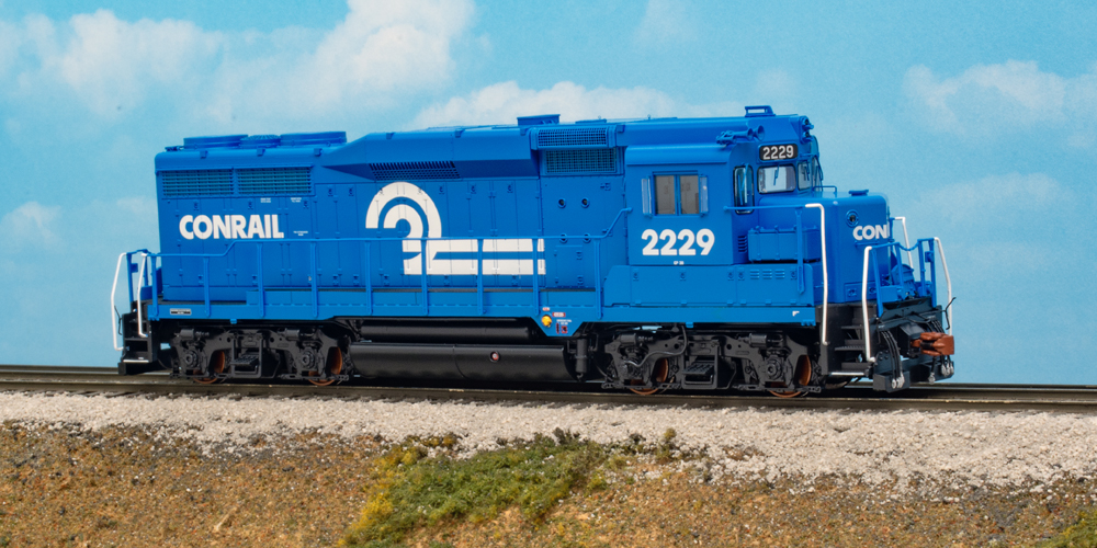 Color photo of HO scale engine painted blue and black on scenic base.