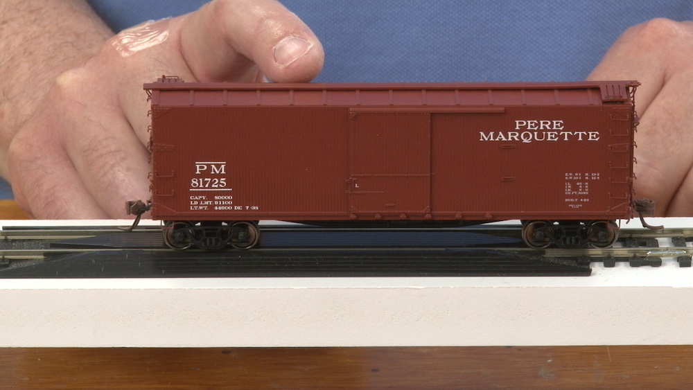 HO scale boxcar being tipped from side to side