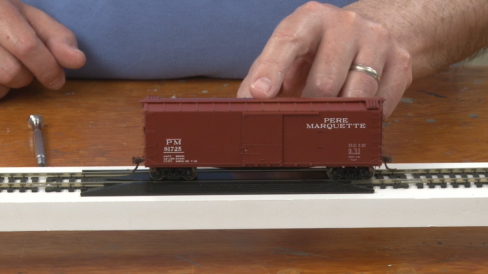 HO scale boxcar being tipped from side to side