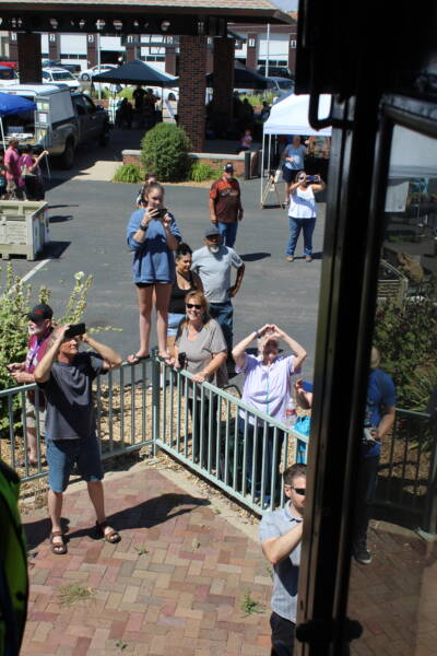 people by fence taking photos