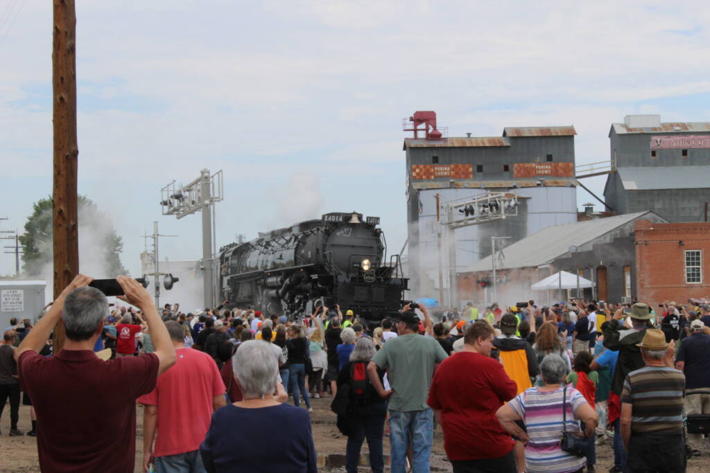 people taking photos of train in the distance