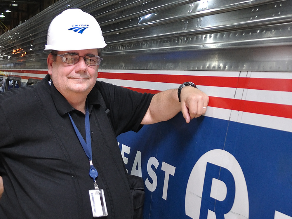 man with hard hat next to Amtrak