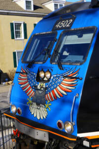 Close-up front view of blue electric passenger locomotive with Bald Eagle graphic.