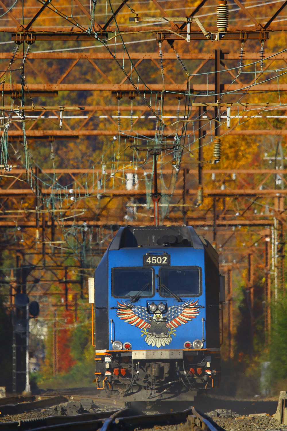 Blue electric passenger locomotive running under catanery. More Jersey-style eye candy