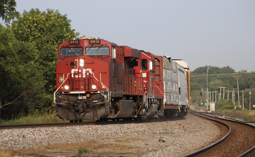 Train with two red locomotives rounding curve