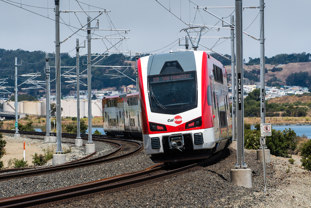 Red and white electric trainset rounds curve