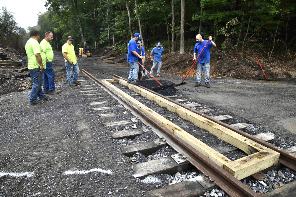 Workers prepare crossing for new pavement at grade crossing