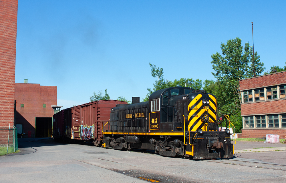 Black and yellow locomotive switching at business