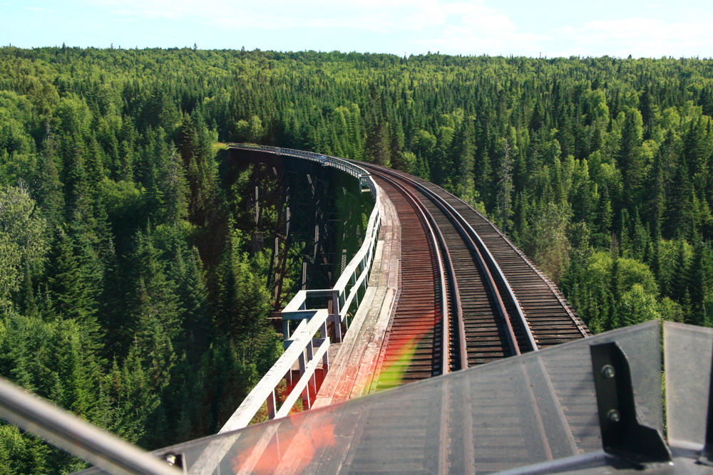 High curving bridge on rail line as seen from locomotive cab