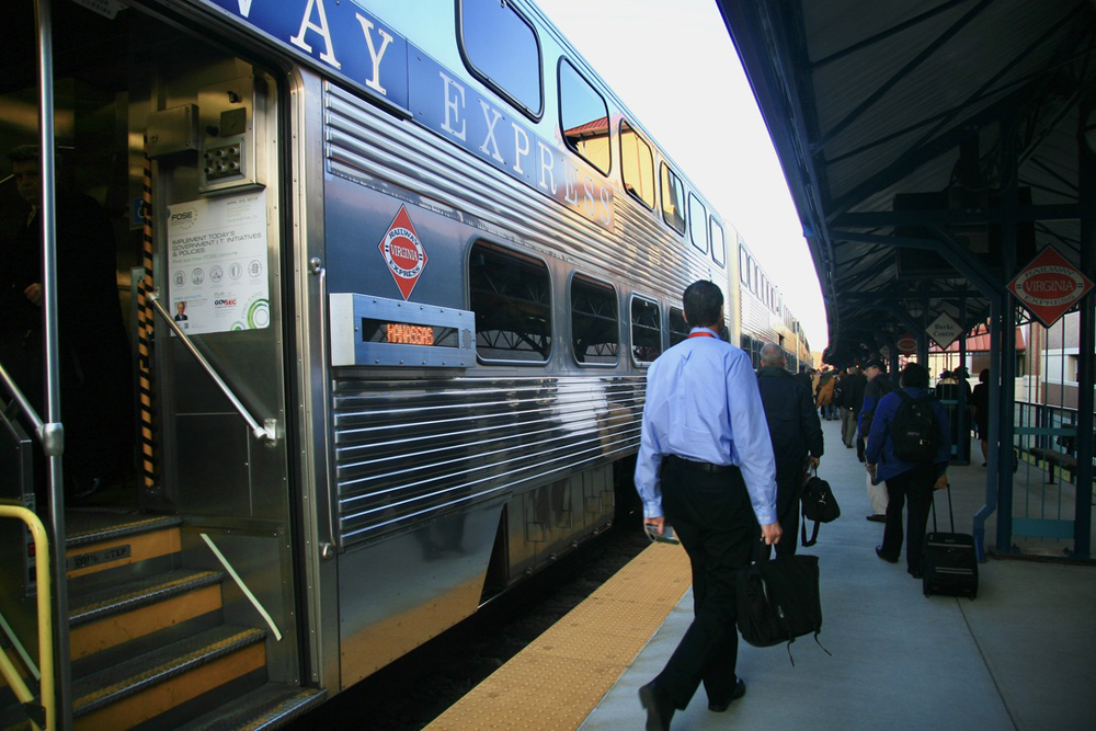 Man walking off bilevel commuter coach at station