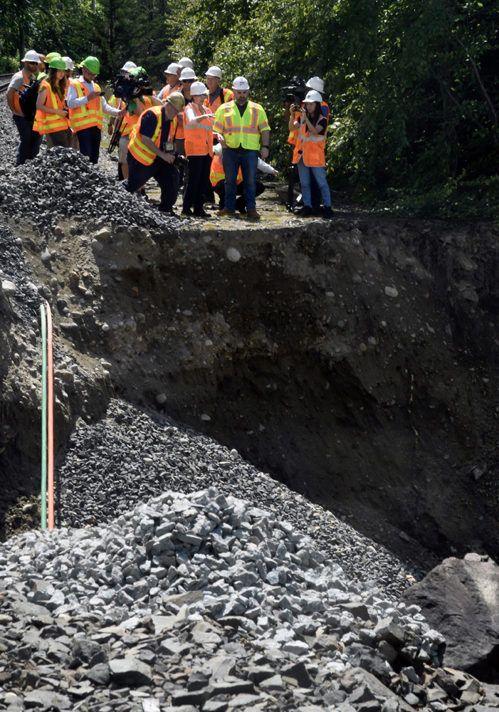 Group of people looking over washout on rail line