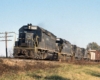 Three black diesel Atlanta & West Point locomotives with freight train on elevated trackage