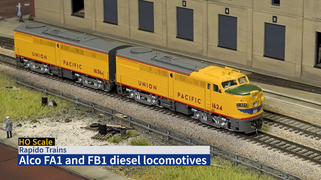 Screen capture from video showing two HO scale diesels painted yellow and gray.