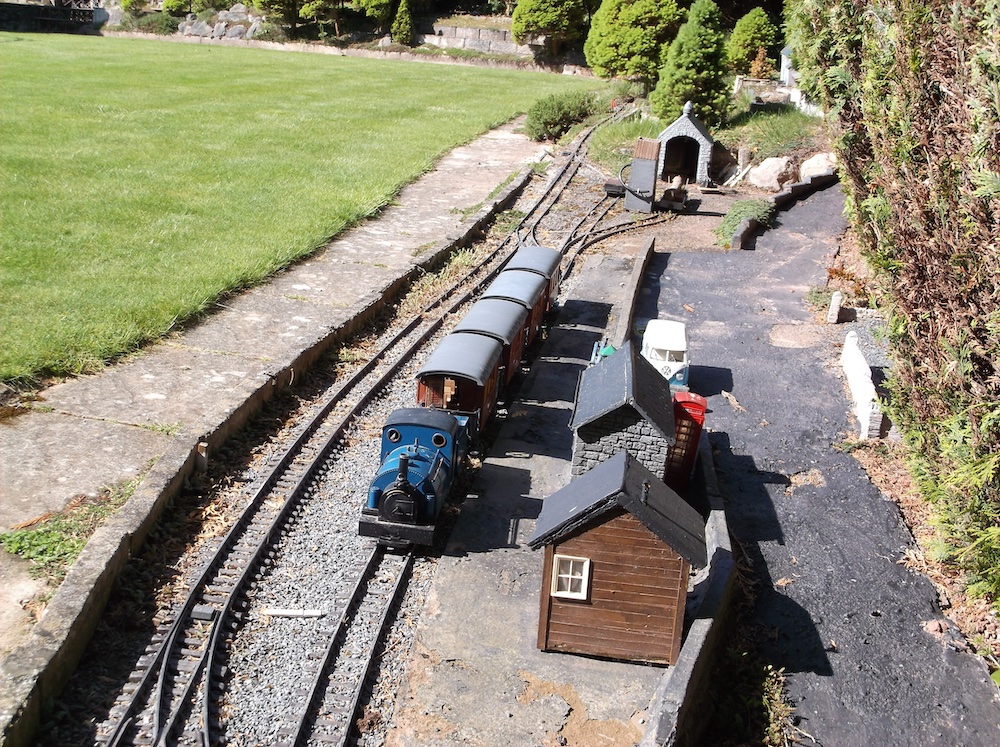 train next to a station on garden railway; adventure in imagination