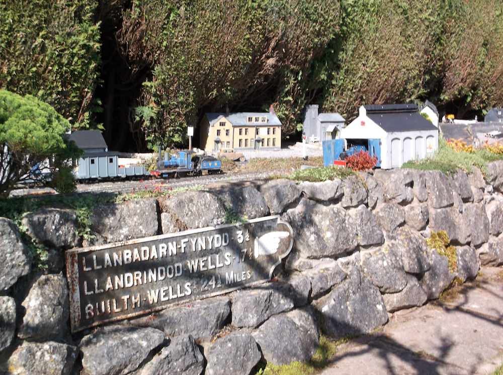 model train with rock retaining wall and metal sign