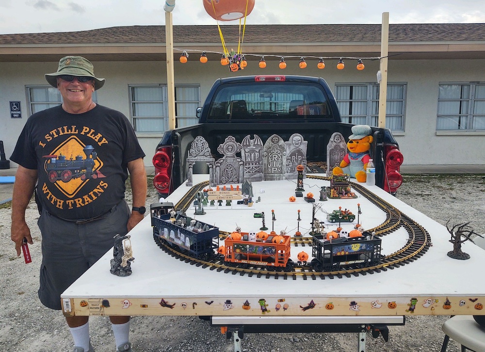 man standing next to large scale display