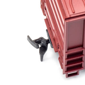 A black plastic coupler on the end of a red boxcar