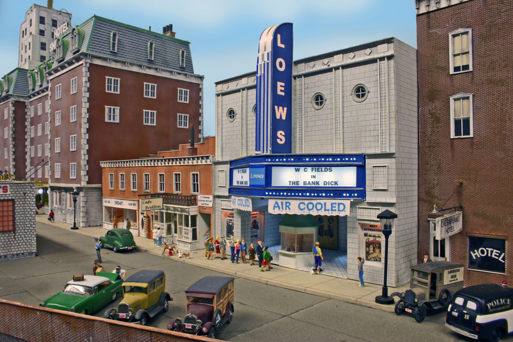 Color photo of HO scale layout with buildings, figures, and vehicles.