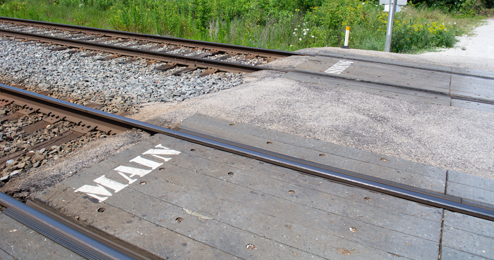 Color photo showing grade crossing with stencils on the crossing mats.