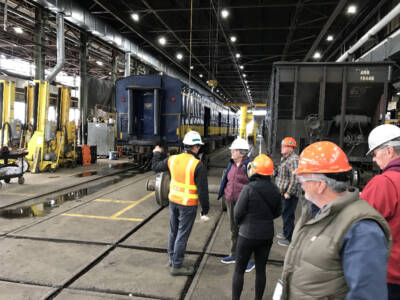 Freight and passenger cars inside shop building.