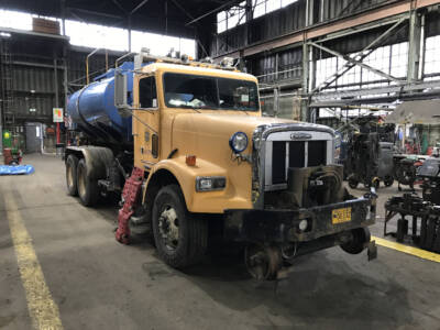 Yellow truck with blue fuel tank attachment.