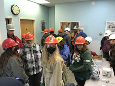 Group of people in PPE in conference room.