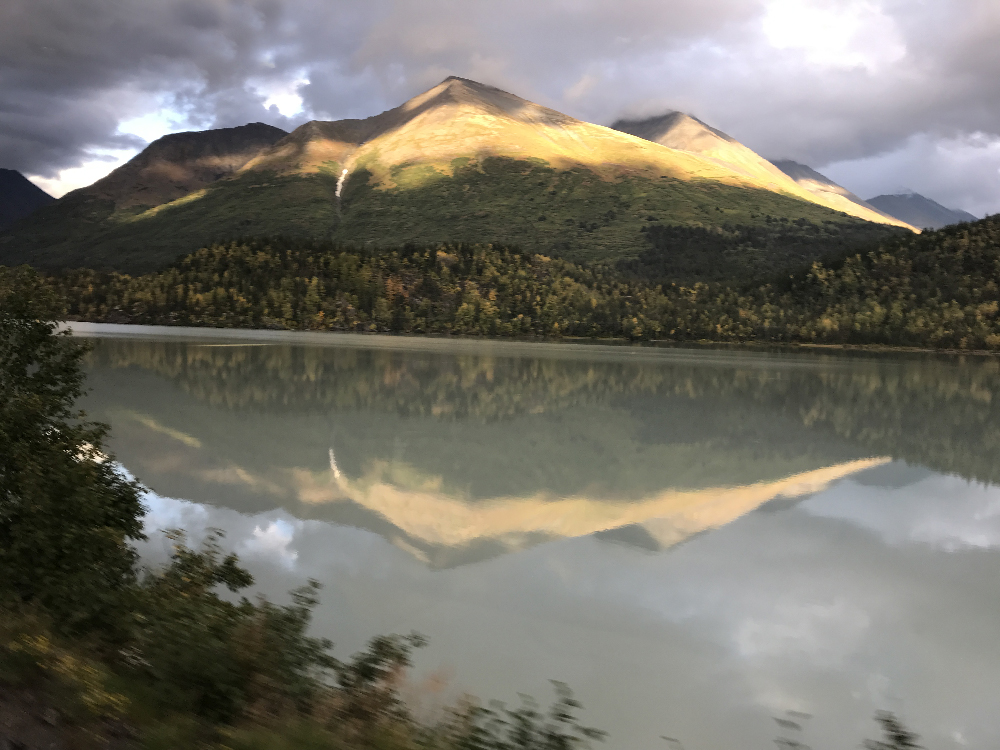 sunset on a mountain reflected in lake below